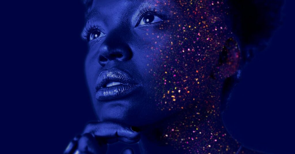 Mesmerizing portrait of a woman with glitter makeup and dramatic lighting.